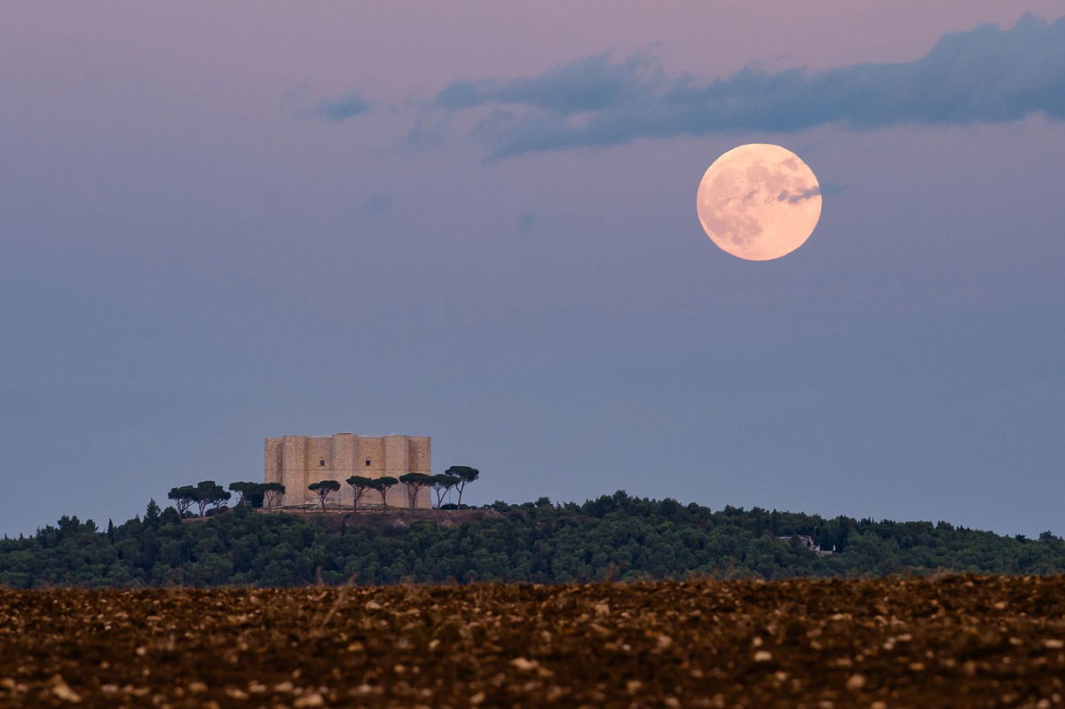 <i>Davide Pischettola/NurPhoto/Shutterstock via CNN Newsource</i><br/>The full hunter's moon rises behind Castel del Monte in Andria