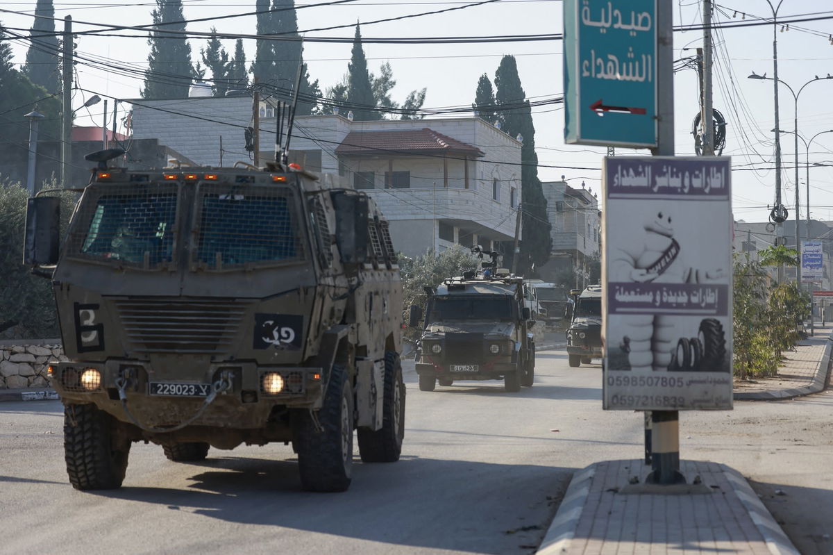 <i>Jaafar Ashtiyeh/AFP/Getty Images via CNN Newsource</i><br/>Israeli army vehicles drive down a road during a raid in Qabatiya