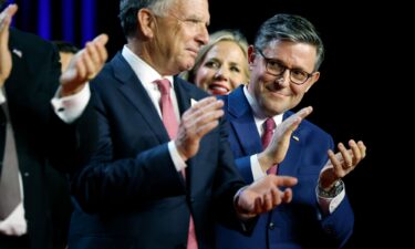 Speaker of the House Mike Johnson applauds on stage as Republican presidential nominee