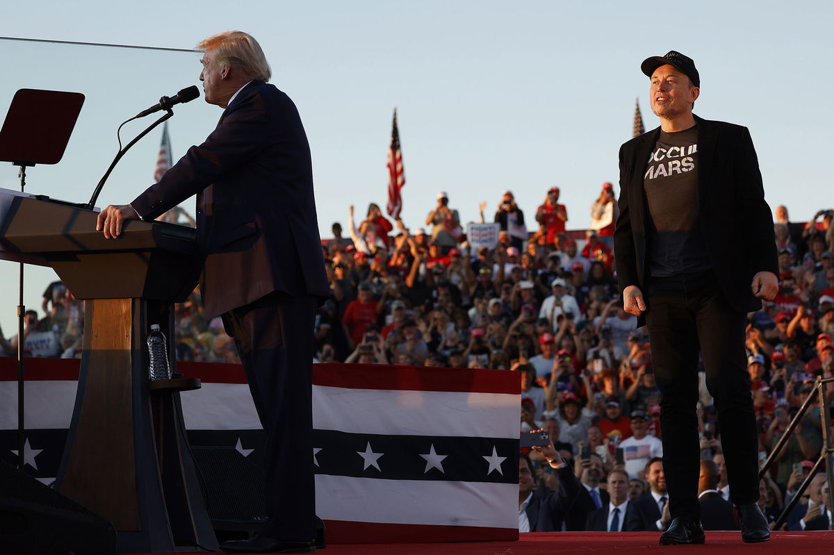 Elon Musk steps onto stage as Republican presidential nominee, former President Donald Trump addresses a campaign rally from behind bullet resistant glass at the Butler Farm Show fairgrounds on October 05, in Butler, Pennsylvania.