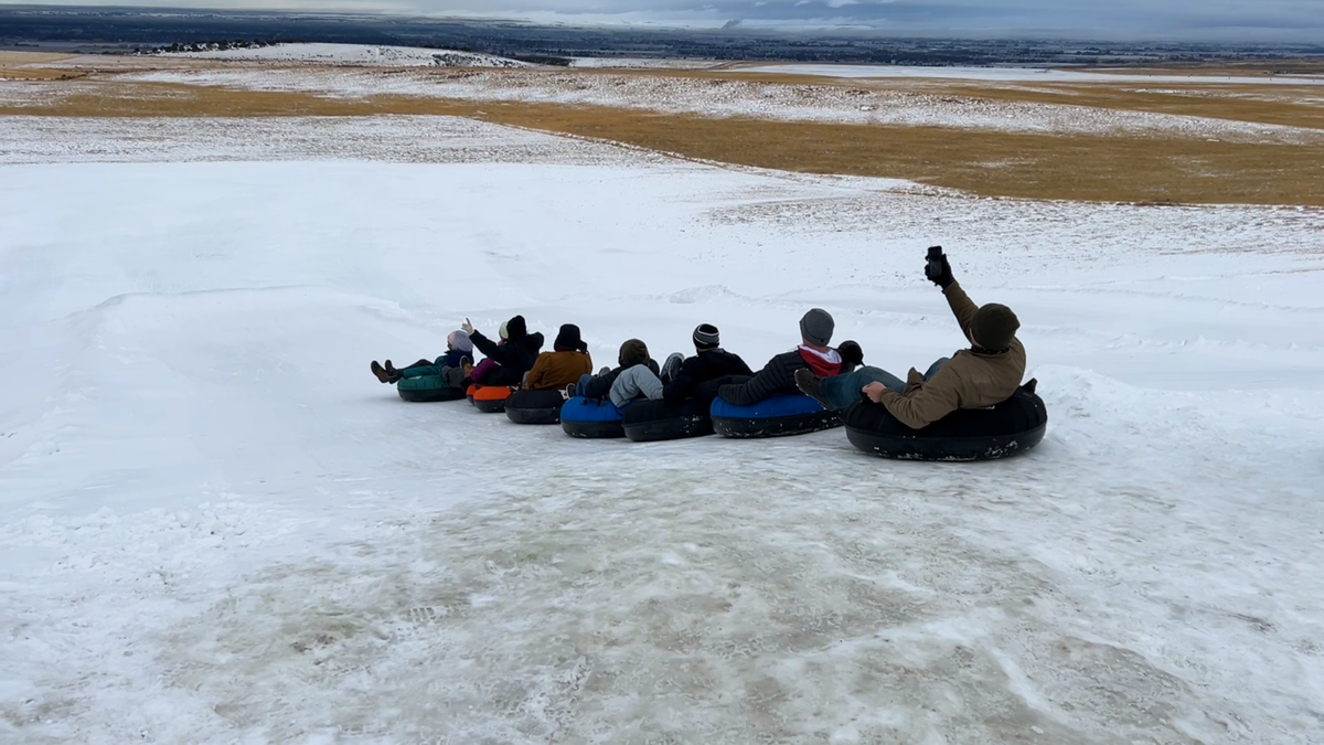 Several people like to go down the snow hill in groups