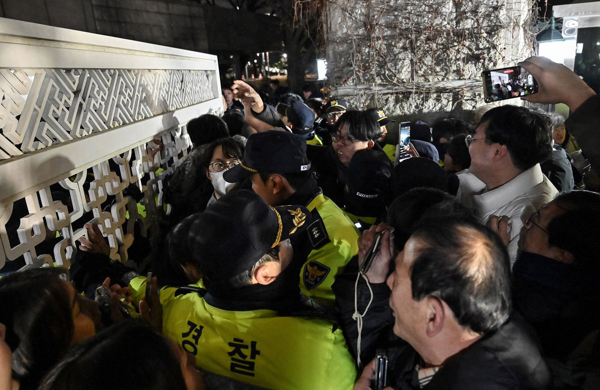 <i>Jung Yeon-je/AFP/Getty Images via CNN Newsource</i><br/>Police attempt to hold back people trying to enter the National Assembly in front of the main gate in Seoul