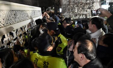 Police attempt to hold back people trying to enter the National Assembly in front of the main gate in Seoul