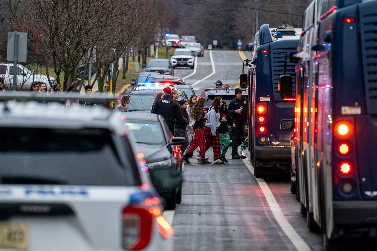 Students from Abundant Life Christian School are escorted to a city bus to be reunited with their parents after a school shooting on December 16 in Madison, Wisconsin.