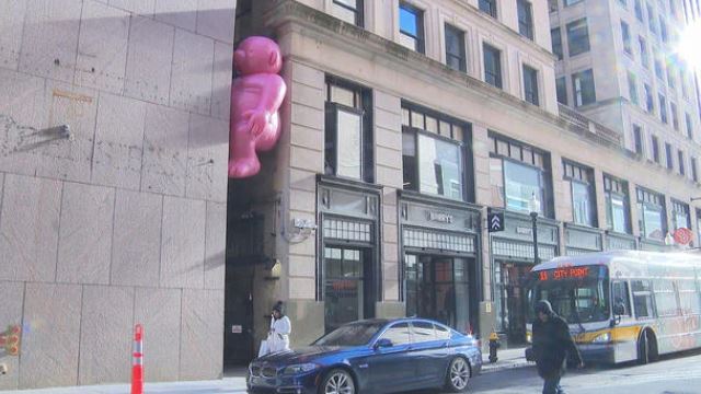 <i>WBZ via CNN Newsource</i><br/>Giant pink people peering into restaurant windows and hanging out in alleyways.