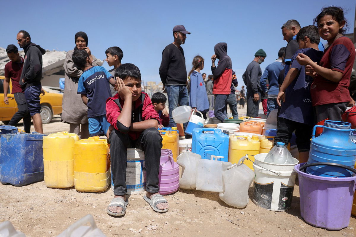 <i>Bashar Taleb/AFP/Getty Images via CNN Newsource</i><br/>Palestinians attempt to collect water at a camp for displaced people in Gaza City