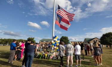 Students and community members make a prayer circle around a makeshift memorial outside Apalachee High School in September 2024 in Winder
