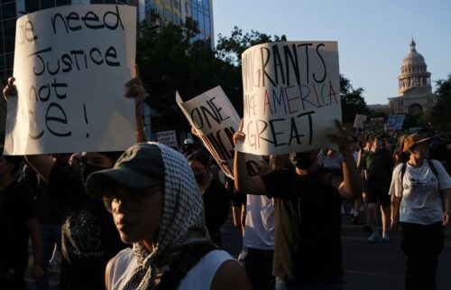 Demonstrators hold signs Monday during a rally in Austin