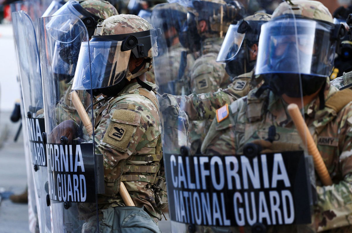 <i>David Swanson/Reuters via CNN Newsource</i><br/>National Guard troops wear gas masks during protests against federal immigration sweeps