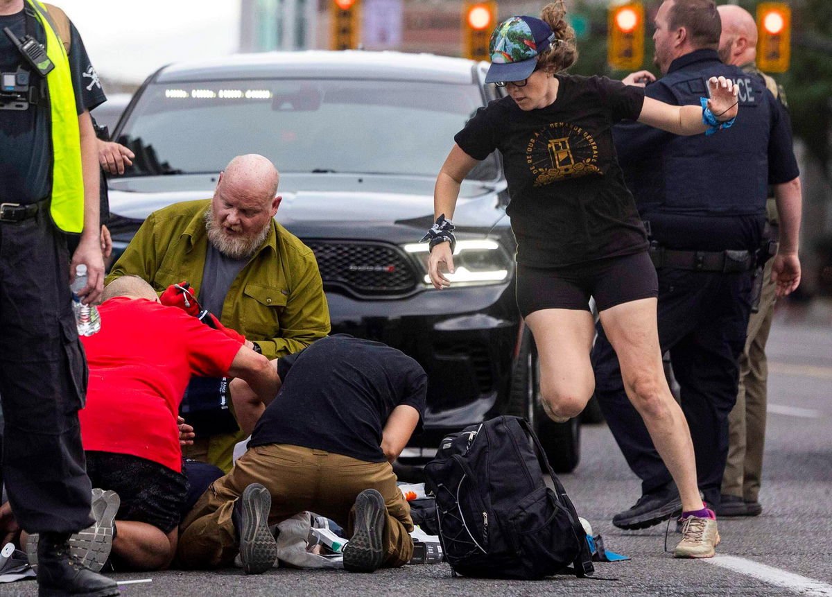 People rush to give medical assistance to a man shot during a “No Kings” protest in Salt Lake City on June 14,.