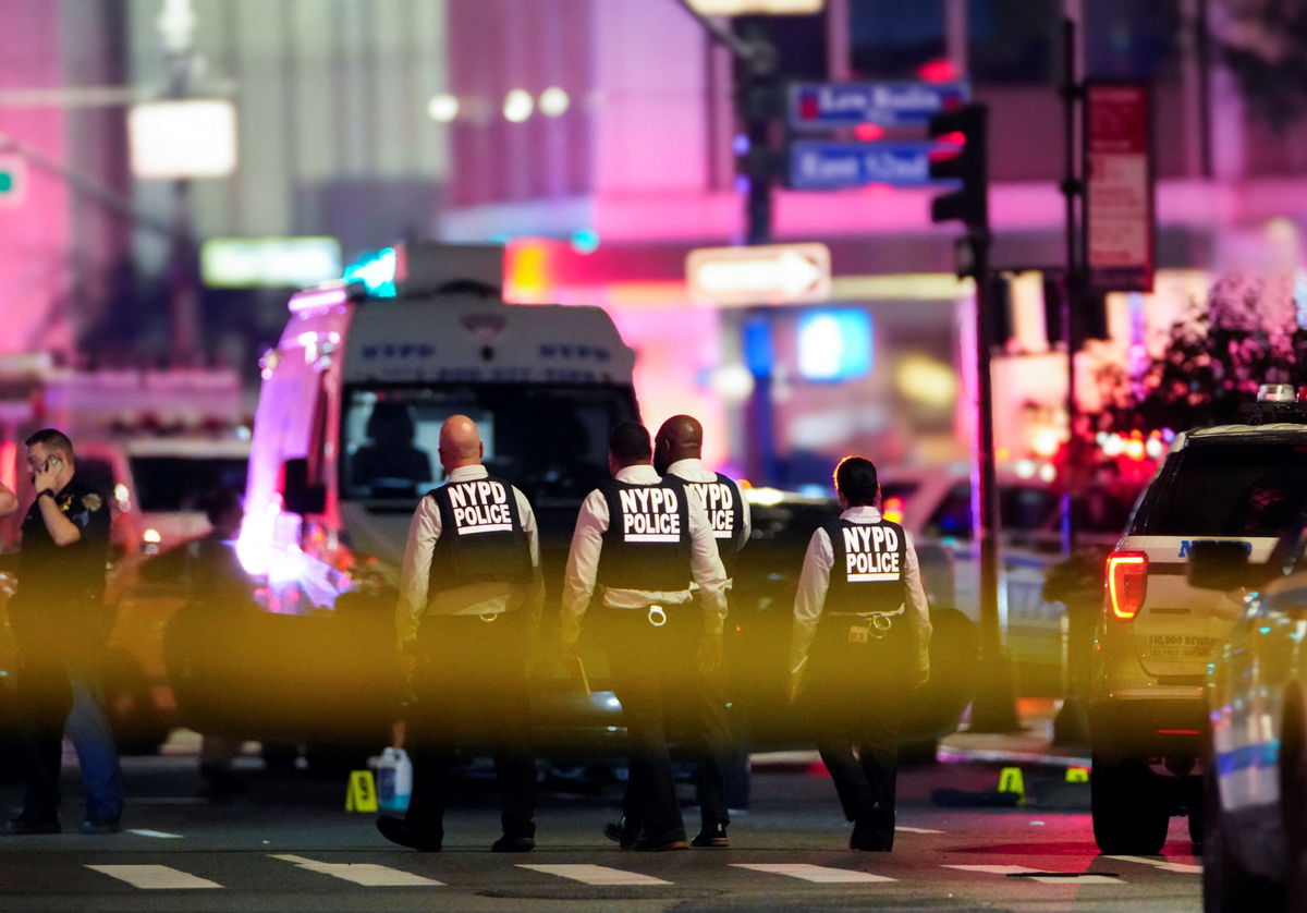 NYPD officers work near the scene of shooting in Manhattan Monday.